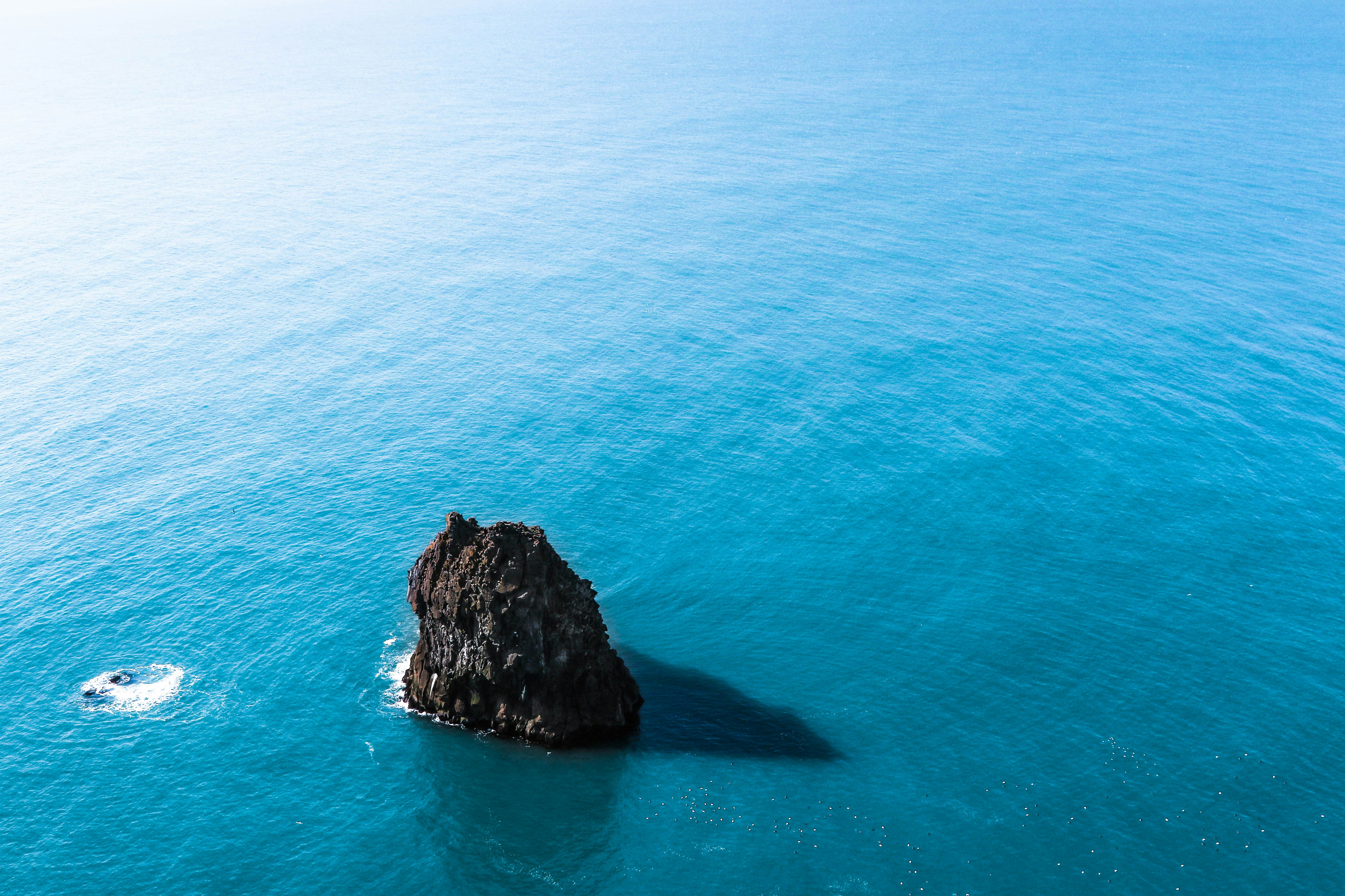 brown rock formation on body of water